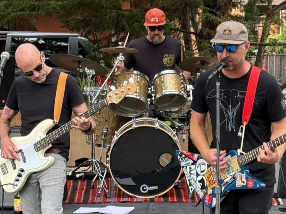 Torpedo Wharf playing outdoors at San Rafael Porchfest, bass, drums and guitar in a row