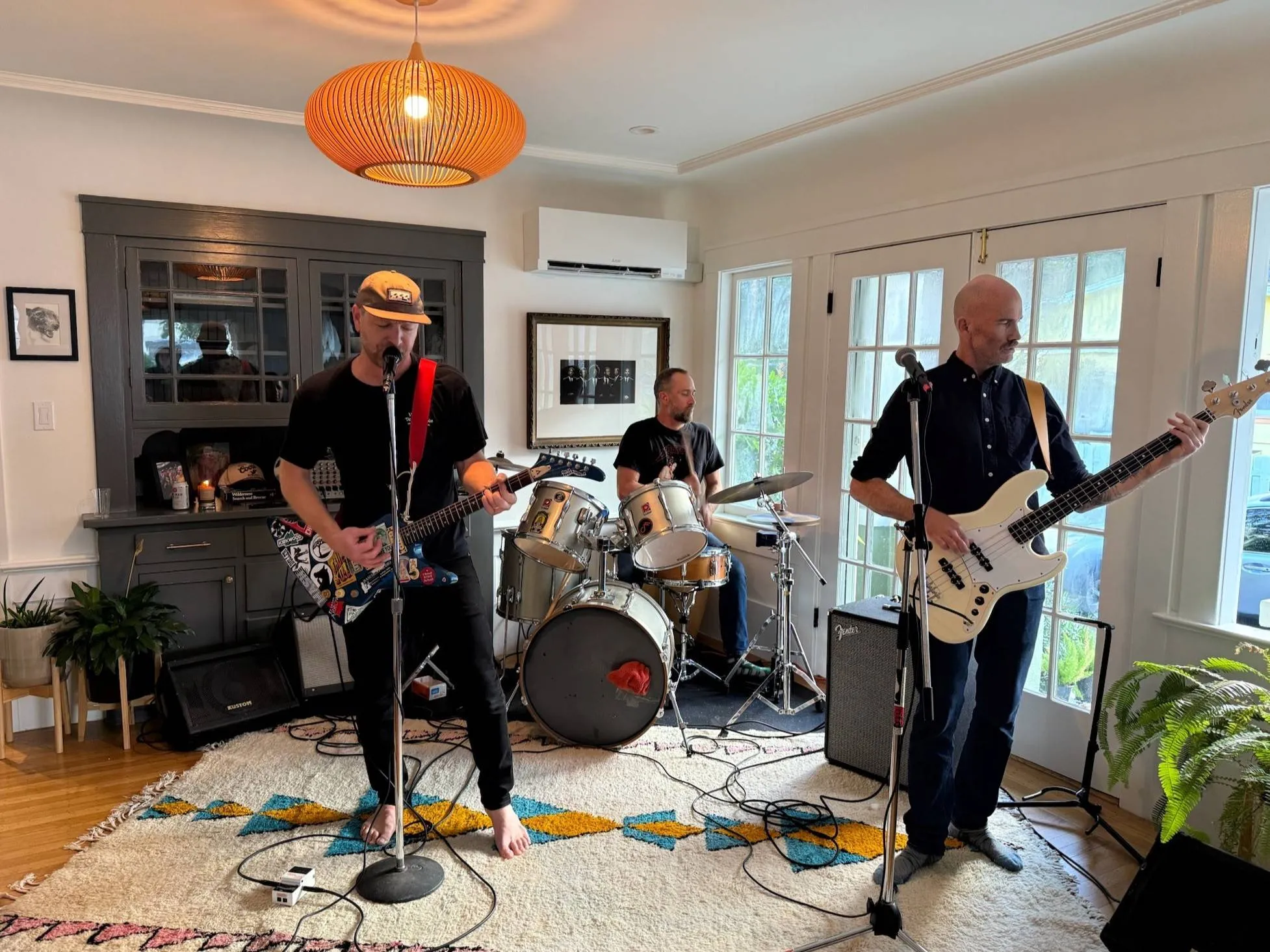 Torpedo Wharf playing a living room show on a patterned rug under an orange pendant lamp